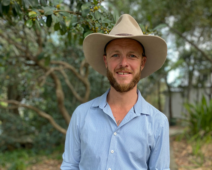 Dan co owner of Bohemi wearing an akubra hat with trees in the back ground